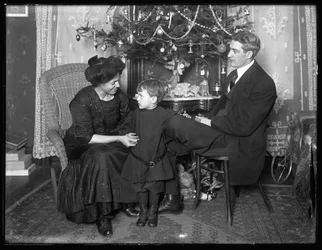 Dan Seymour och familj i informell pose, sittande under en julgran, julen 1912