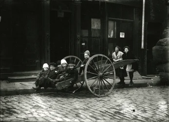 Grupp barn i vagn, med flicka och kvinna stående bakom, c.1910-21