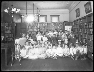 Gruppporträtt av barn i läsesalen i en oidentifierad filial av Queens Borough Public Library, ca 1910
