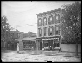 Sju barn poserar framför en oidentifierad filial av Queens Borough Public Library, New York, ca 1910