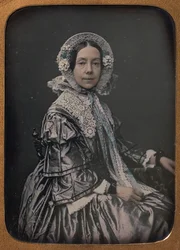Sittande medelålders kvinna klädd i finesser, 1854-60.