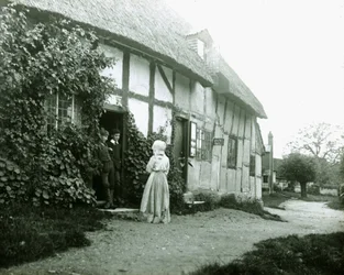 "Människor på tröskeln till en stuga" (People at a cottage door)