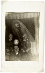 Paranormalt fenomen: porträtt av tre gamla människor, andan av en kvinna som dyker upp bakom dem, cirka 1920 Fotografi av William Hope (1863-1933)
