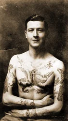 Porträtt av en man med elaborerade tatueringar, cirka 1920